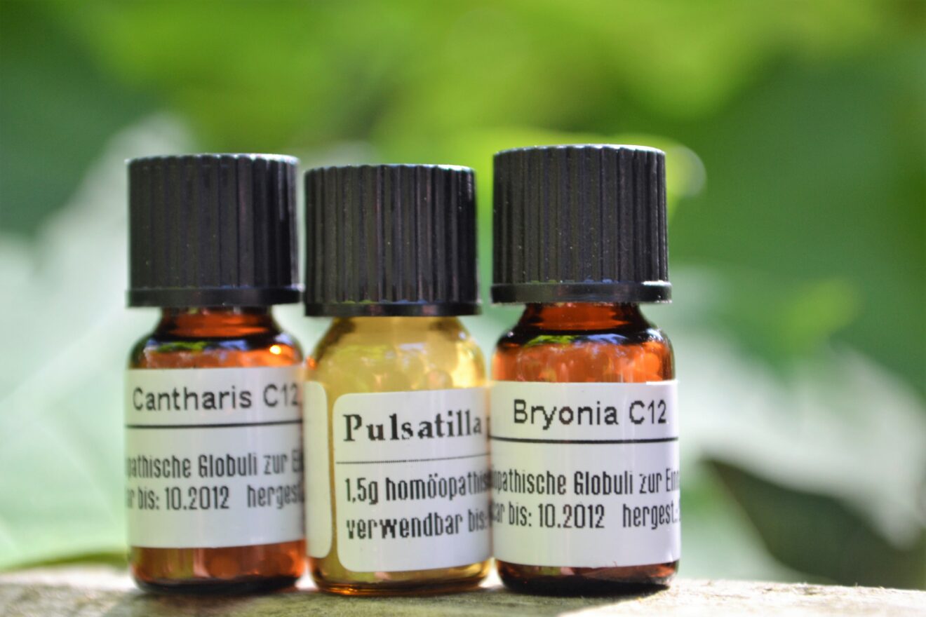 Homöopathie - Drei Globuli-Fläschchen im Grünen aufgenommen
